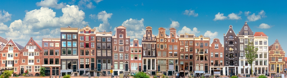 Amsterdam,Long,Panorama,Of,Famous,Amsterdam,Houses,With,Blue,Sky.